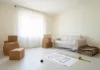 Meubler un F3 neuf avec un petit budget : par où commencer ? Salon d'un appartement neuf en cours d'aménagement avec cartons et canapé