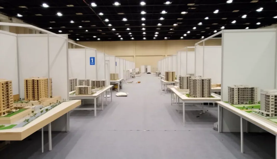 Stands d’un salon de l’immobilier avec maquettes de résidences